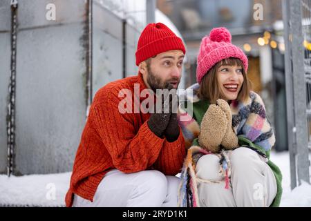 Ein junges Paar sitzt im Winter auf der Veranda ihres Hauses Stockfoto