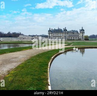 Chateau de Chantilly (Frankreich) und Schwäne im Teich. Das Grand Chateau wurde in den 1870er Jahren (Architekt Honore Daumet) umgebaut. Stockfoto