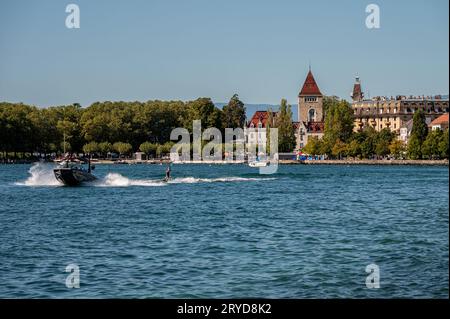 Ouchy, Lausanne, Waadtländer Kanton, Schweiz - 24. September 2023 : Motorboot mit Menschen Wakeboarding. Genfer See und Burg Ouchy. Stockfoto
