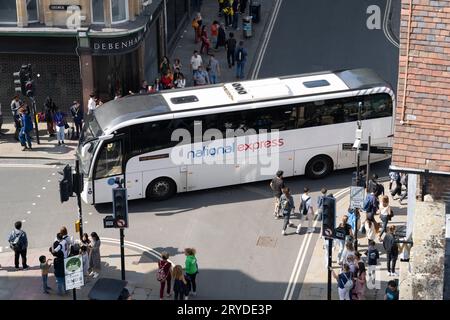 Aus der Vogelperspektive eines National Express-Reisebusses, der von der Broad Street aus über eine 4-Wege-Kreuzung im Zentrum von Oxford fährt. UK. Konzept: Busreisen Stockfoto