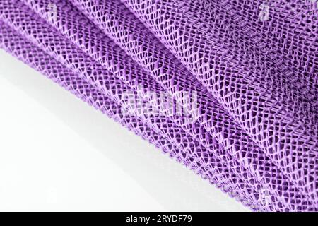 Eine Lavendelfarbene synthetische Küchenserviette ist wie ein Ventilator auf weißem Hintergrund gefaltet. Stockfoto