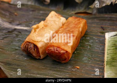 Gebratene Frühlingsbrötchen serviert auf grünen Bananenblättern Stockfoto