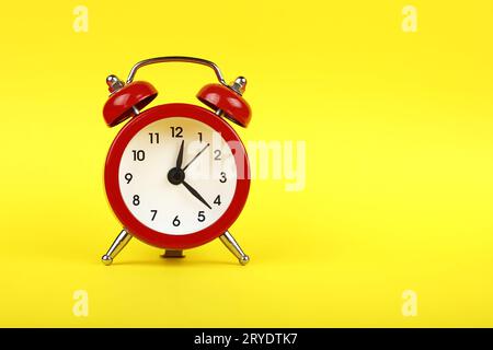 Schließen Sie einen roten Wecker auf gelbem Hintergrund Stockfoto