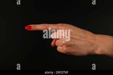 Frauenhand zeigt mit Zeigefinger über Schwarz Stockfoto