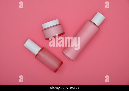 Set mit Kosmetik-Creme-Flaschen auf rosa Stockfoto