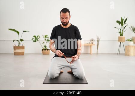 Kaukasischer Mann mit Bart, der Yoga-Meditation macht. Männliche Konzentrationserscheinungen mittleren Alters geschlossen Stockfoto