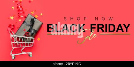 Warenkorb mit Geschenkbox und Konfetti auf rotem Hintergrund. Angebot „Black Friday“ Stockfoto