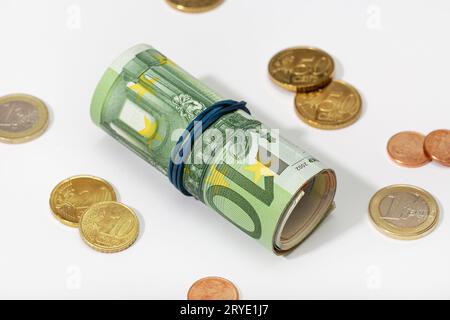 Rolle von Euro-Banknoten mit Gummiband und Münzen isoliert auf weißem Hintergrund Stockfoto