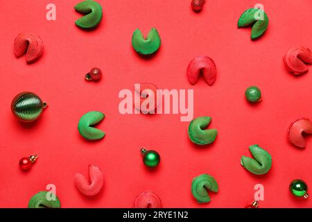 Glückskekse und Weihnachtskugeln auf rotem Hintergrund Stockfoto