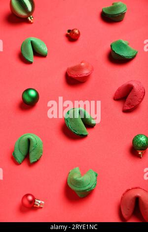 Glückskekse und Weihnachtskugeln auf rotem Hintergrund Stockfoto