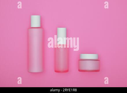 Set mit Kosmetik-Creme-Flaschen auf rosa Stockfoto