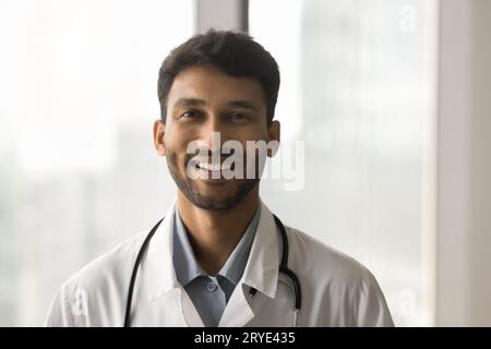 Positiv attraktiver indischer Arzt-Mann im Weißen Fellkopfschuss Stockfoto