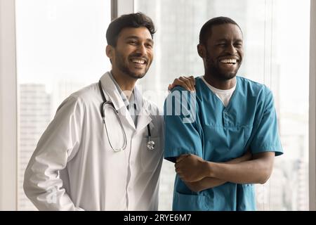 Glückliche multiethnische junge medizinische Kollegen Männer stehen zusammen Stockfoto