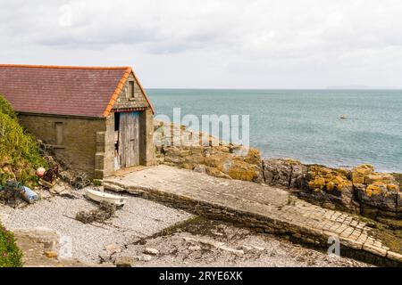 Die alte Rettungsbootstation oder das alte Haus, jetzt veraltet und überflüssig, Moelfre, Anglesey, Nordwales, Vereinigtes Königreich, Querformat Stockfoto