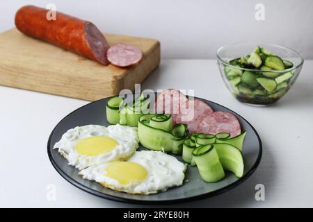 Zastrak-Eier Rühreier Wurst Salat Gurken auf der Trael Blick von der Seite oben. Traditionelles englisches amerikanisches Frühstück. Erste Mahlzeit. Das Benef Stockfoto