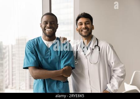 Fröhlich hübsche, diverse Ärzte posieren für Porträts in Innenräumen Stockfoto