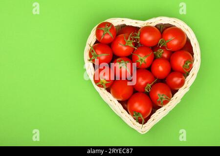 Kirschtomaten in Herzform Warenkorb auf Grün Stockfoto