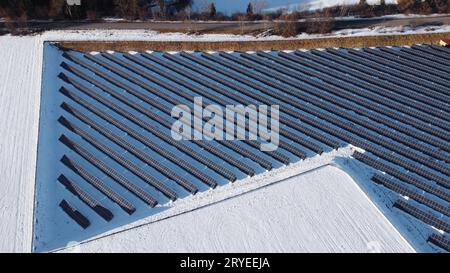 Luftaufnahme mit Drohne eines großen Solarparks auf der Wiese im Winter Stockfoto