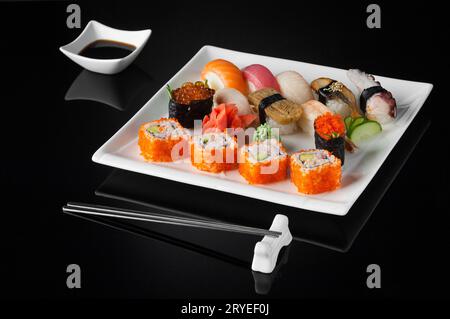 Sushi auf einem Teller auf schwarzem Hintergrund Stockfoto