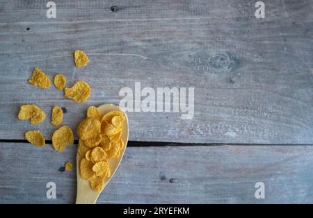 Mehrfarbige Müslischlaufen und Milch in einer Schleife, goldener Löffel auf grauem Hintergrund. Draufsicht, Kopierbereich. Frühstückskonzept Stockfoto