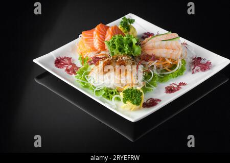 Sushi auf einem Teller auf schwarzem Hintergrund Stockfoto