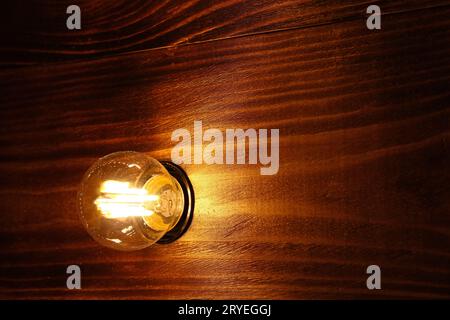 Eine Glühlampe über Holzoberfläche Stockfoto