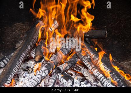 Brennende Holzstämme auf Steinofen Stockfoto