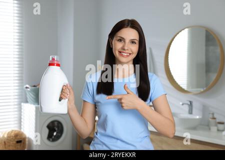 Schöne Frau, die im Badezimmer einen Weichspüler zeigt Stockfoto