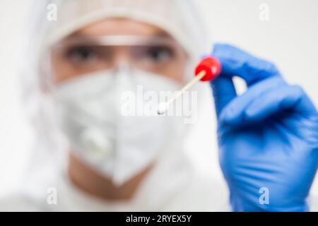 Medizinischer NHS-Mitarbeiter in persönlicher Schutzausrüstung, der den Probenentnahmestab für Coronavirus-Tupfer hält Stockfoto