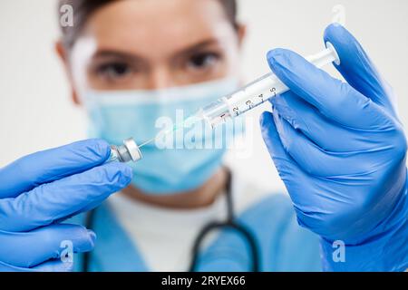 UK NHS junge kaukasische weibliche Hausärztin mit Impfstoffspritze Stockfoto