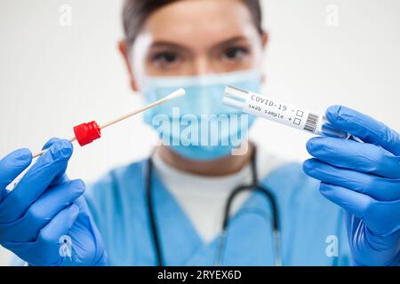Weibliche Ärztin in Großbritannien, die persönliche Schutzausrüstung trägt, die den Coronavirus COVID-19 rt-PCR-Test durchführt Stockfoto