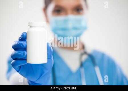 Weiblicher Hausarzt UK NHS Allgemeinarzt Arzt hält weiße leere Flasche Pillen Stockfoto