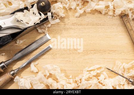 Tischlerei- oder Holzwerkhintergrund mit Kopierraum. Alte Zimmermannswerkzeuge und Holzspäne auf einer Werkbank Stockfoto
