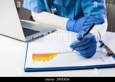 Arzt mit Schutzhandschuhen zur Analyse von COVID-19-Info-Daten Stockfoto