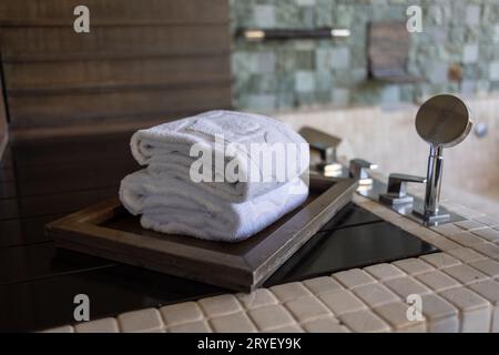 Sauberes Handtuch auf der großen Whirlpool-Badewanne Stockfoto