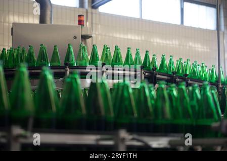 Abfüllung von Mineralwasser in grünen Flaschen Stockfoto