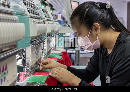 Kota Kinabalu, Sabah, Malaysia - 10. November 2021 : Eine Arbeiterin mit medizinischer Gesichtsmaske ist in der Textilbranche bei Garm tätig Stockfoto