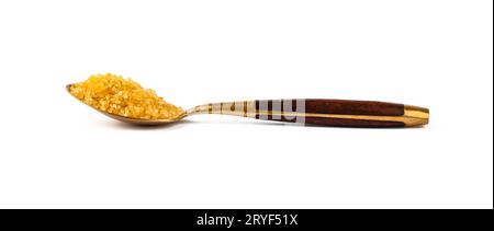 Goldener Löffel voller braunem Rohrzucker Stockfoto