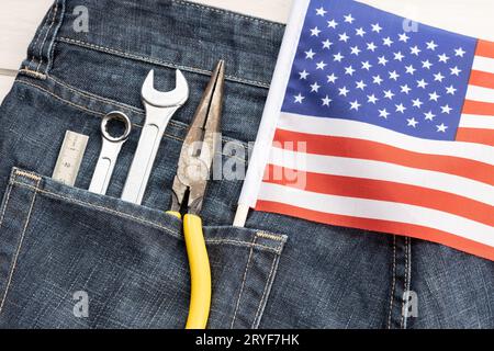 Set mit Werkzeugen und amerikanischer Flagge in Jeans-Tasche. Hintergrundkonzept für den Arbeitstag Stockfoto