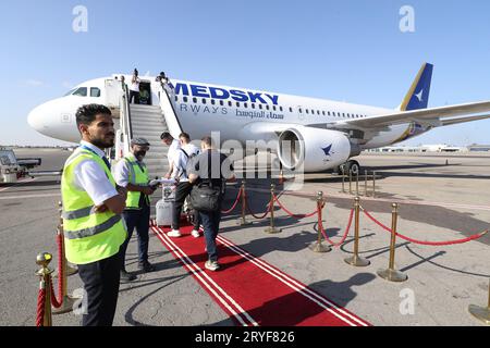 Tripolis, Libyen. September 2023 30. Passagiere gehen an Bord eines Fluges von Medsky Airways am Mitiga International Airport in Tripoli, Libyen, 30. September 2023. Ein Flug nach Rom startete am Samstag hier in der libyschen Hauptstadt und nahm nach fast zehn Jahren Halt die direkten Linienflüge zwischen Libyen und Italien wieder auf. Quelle: Hamza Turkia/Xinhua/Alamy Live News Stockfoto