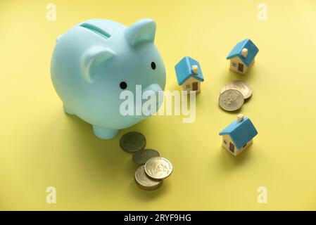 Konzept der Rettung für Haus und Eigentum. Miniaturhaus mit Schweinebank. Stockfoto
