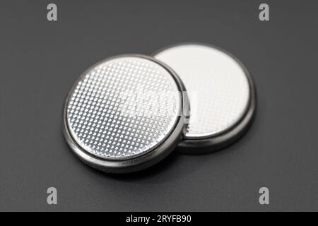 Knopfzellenbatterie oder Knopfzellenbatterie auf schwarzem Hintergrund isoliert Stockfoto
