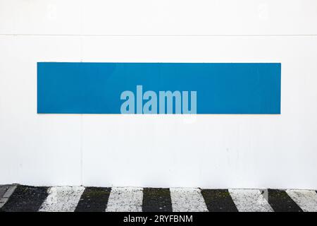 Weißes blaues Schild an der weißen Wand an der Außenseite des Gebäudes. Mustervorlage Stockfoto