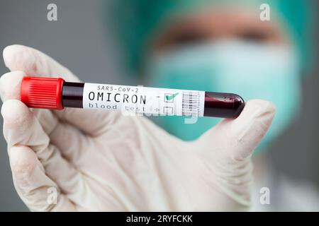 Arzt medizinischer Arbeiter hält Probenhalter mit Omicron Variant Coronavirus Patient Blutprobe Stockfoto