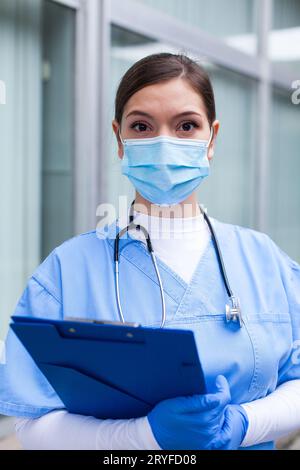 Nahaufnahme-Porträt einer Ärztin in blauer Uniform mit Klemmbrett Stockfoto