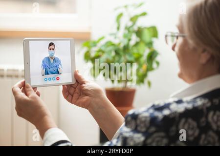 Ältere Patientin im Gespräch mit einer jungen Ärztin per Videoanruf Stockfoto