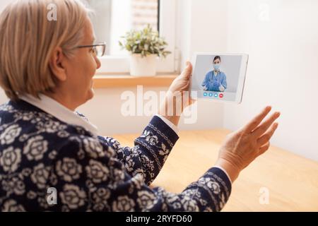 Ältere Patientin im Gespräch mit einer jungen Ärztin per Videoanruf Stockfoto