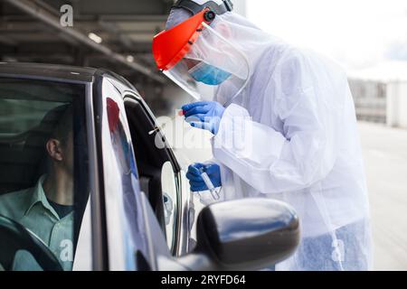 Medizinisches Fachpersonal, das Patientenproben in Coronavirus-Fahrt durch die Einrichtung sammelt Stockfoto