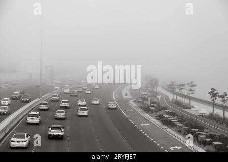 Abu Dhabi, VAE - 8. April 2021: Nebeliger Morgen in Abu Dhabi, Verkehr auf der Straße Stockfoto