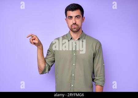 Ein gutaussehender Mann, der den Buchstaben X x mit den Fingern zeigt. Das Alphabet in der amerikanischen Gebärdensprache (ASL). Isoliertes blaues Hintergrund-Nahaufnahme-Portrait Stockfoto